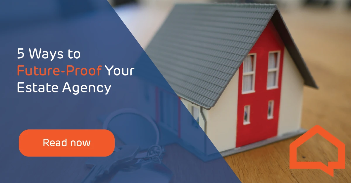 An image of a model house on a key ring placed on a wooden desk